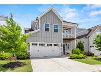 Charming gray two-story home with a white garage door, front porch, and manicured landscaping at 553 Onyx Lndg, Marietta, GA 30064