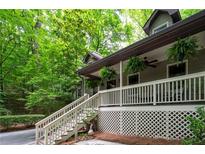 Inviting covered front porch with white railings, steps and lush greenery, creating a welcoming entrance at 1560 Bubbling Creek Ne Rd, Atlanta, GA 30319