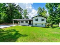 Charming two-story home with a well-maintained lawn, carport, and classic curb appeal at 550 Oglesby Bridge Se Rd, Conyers, GA 30094