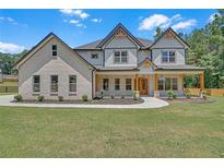Inviting two-story home with brick and siding, featuring a covered porch and manicured front yard at 1461 Leach Dr, Lawrenceville, GA 30045