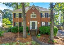 Charming two-story brick home with black shutters and manicured landscaping at 2151 Hamstead Ct, Suwanee, GA 30024