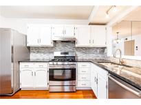 Bright kitchen with stainless steel appliances, white cabinets, and tile backsplash at 2901 Lenox Ne Way # 902, Atlanta, GA 30324