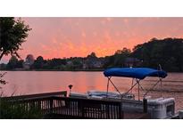 Beautiful waterfront view at sunset featuring a boat docked at the pier, perfect for serene living at 3800 Schooner Rdg, Alpharetta, GA 30005