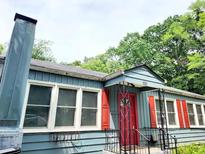 Charming home featuring blue siding, red shutters, a striking red front door, and a classic chimney design at 2404 Shallowford Ter, Atlanta, GA 30341