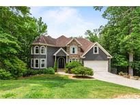 Charming two-story home with stone accents, attached garage, lush lawn and mature trees at 2990 Hearthstone Dr, Cumming, GA 30041