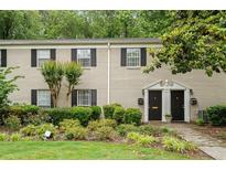 Charming two-story townhome featuring black shutters, well maintained lawn, and a landscaped front yard at 3663 Essex Ave # 29, Atlanta, GA 30339
