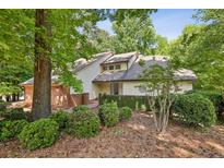 Charming home with brick accents and mature trees providing shade and curb appeal at 110 Westchester Way, Alpharetta, GA 30005