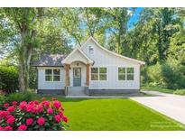 Charming single-Gathering home featuring a manicured lawn, colorful flowers, and inviting front porch at 3275 Dodson Dr, East Point, GA 30344