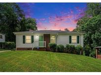 Charming single-story home featuring a well-manicured lawn, white siding, and green accents, perfect for cozy living at 3650 Croft Nw Pl, Atlanta, GA 30331