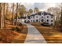 Elegant two-story home featuring a long driveway and manicured landscaping at 5211 Powers Ferry Rd, Sandy Springs, GA 30327