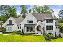 Stunning traditional home featuring a manicured lawn, light brick, and an elegant arched entryway at 3379 Rennes Ne Dr, Brookhaven, GA 30319