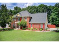 Inviting brick two-story home featuring a well-manicured lawn and complemented by mature trees at 452 Emerald Trce, Jonesboro, GA 30236