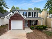 Charming two-story home with a brick facade, a garage, and lovely landscaping at 4817 Enclave Dr, Union City, GA 30291