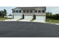 Three townhomes each with a white garage door and neutral color scheme at 8660 Webb Rd, Riverdale, GA 30274