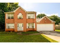 Charming brick two-story home with a well-manicured lawn and an attached two-car garage at 3730 Warriors Path, Decatur, GA 30034