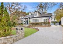 Charming two-story home with manicured front lawn, stone mailbox post, and a curved driveway at 1466 University Dr, Atlanta, GA 30306