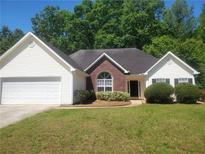 Charming one-story home with manicured lawn, brick accents, and an attached two-car garage at 155 Overlook Dr, Covington, GA 30016