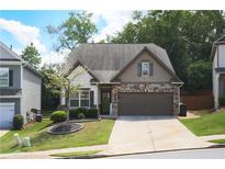 Charming home with stone accents, well-manicured lawn, and inviting curb appeal at 103 Prominence Ct, Canton, GA 30114