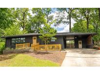 Charming home featuring a black brick exterior, wooden details, and a well-manicured front yard at 2382 Whites Mill Ln, Decatur, GA 30032