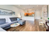 Bright, open-concept living room featuring hardwood floors and a gray sectional sofa with modern decor at 1418 Dresden Ne Dr # 385, Brookhaven, GA 30319