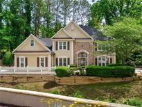 Charming two-story home featuring a stone facade, manicured landscaping, and a welcoming entrance at 9195 Tuckerbrook Ln, Alpharetta, GA 30022