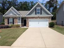 Charming single-story home with a two-car garage, brick and siding, and a well-manicured lawn at 131 Prominence Ct, Canton, GA 30114