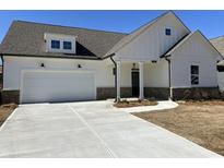 Charming exterior with a two-car garage, brick accents, and a well-manicured lawn at 204 Saratoga Dr, Acworth, GA 30102