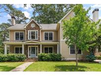 Charming two-story home featuring stone accents, a covered porch, lush landscaping, and a well-manicured lawn at 2217 Virginia Ne Pl, Atlanta, GA 30305