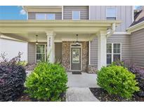 Charming covered front porch with brick accents and manicured landscaping, offering a welcoming entrance to the home at 2450 Overlook Ave, Lithonia, GA 30058