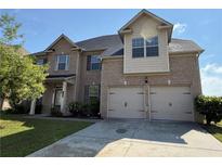 Charming two-story brick home with a well-manicured lawn and attached two-car garage at 3488 Woodshade Dr, Loganville, GA 30052