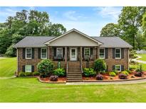 Charming brick home with a welcoming front porch and meticulously landscaped front yard at 4010 Hamilton Mill Rd, Buford, GA 30519