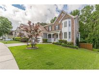 Charming home featuring a well-manicured lawn, brick accents, and a welcoming front porch at 5342 Lakerock Sw Dr, Atlanta, GA 30331
