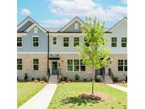 Charming townhome exterior with a well-manicured lawn and inviting entrances at 1240 Ainsworth Aly # 39, Sugar Hill, GA 30518