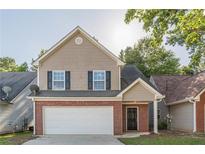 Two-story home featuring a brick-and-vinyl facade with an attached garage and a well-manicured front lawn at 1720 New Orleans Way, Mcdonough, GA 30252