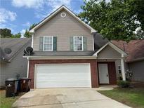 Two-story home with neutral siding, brick accents, and a two-car garage at 1720 New Orleans Way, Mcdonough, GA 30252
