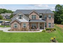 Charming two-story brick home with a well-manicured lawn and inviting front porch at 2109 Cape Ivey Ct, Dacula, GA 30019