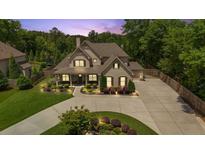 A traditionally styled home with large driveway, manicured lawn, and mature trees at 2205 Beaver Shop Ne Rd, Marietta, GA 30066