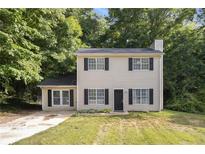 Charming two-story home with black shutters and a welcoming front yard surrounded by lush trees at 430 Pilgrim Ln, Powder Springs, GA 30127