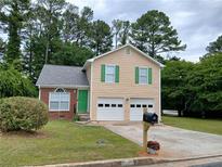 Charming two-story home featuring green shutters, a brick accent, and a well-manicured front lawn at 5517 Rock Shoals Way, Atlanta, GA 30349