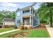 Charming two-story home featuring a covered porch, landscaped yard, and light blue siding at 73 Whitefoord Se Ave, Atlanta, GA 30317