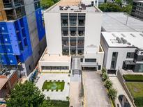 A bird's eye view of a condominium building, showcasing its modern architectural design and the green space and water feature at 1421 Peachtree Ne St # 203, Atlanta, GA 30309