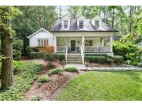 Charming two-story home with a welcoming front porch and lush landscaping at 3251 Pinestream Nw Rd, Atlanta, GA 30327