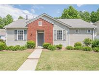 Charming single-story home with manicured lawn, sidewalk and gray vinyl siding with red brick accent at 331 Windcroft Nw Ln, Acworth, GA 30101