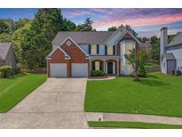 Charming two-story home with a well-manicured lawn and a two-car garage in a lovely suburban neighborhood at 3517 Ridgemill Cir, Dacula, GA 30019