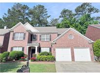 Charming two-story brick home featuring a well-maintained lawn, manicured shrubs and a two car garage at 4056 Kingsley Park Ct, Peachtree Corners, GA 30096