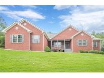 Charming single-story brick home with a manicured front lawn and a welcoming porch at 516 Main St, Hiram, GA 30141