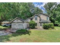 Charming traditional home featuring a two-car garage, manicured lawn, mature trees, and lots of curb appeal at 1464 Yorktown Nw Dr, Lawrenceville, GA 30043