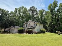 Charming two-story home with well-maintained lawn and mature trees offering a serene and private setting at 1464 Yorktown Nw Dr, Lawrenceville, GA 30043