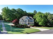 Charming two-story home features a well-manicured lawn and lush landscaping for great curb appeal at 3510 Woodbury Creek Dr, Cumming, GA 30041