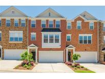 Charming red brick townhouse with a well-manicured front yard and attached garage, perfect for modern living at 3799 Chattahoochee Summit Se Dr # 5, Atlanta, GA 30339